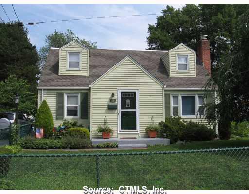 a front view of a house with a yard and green space