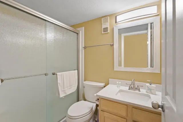 a bathroom with a sink vanity mirror and toilet