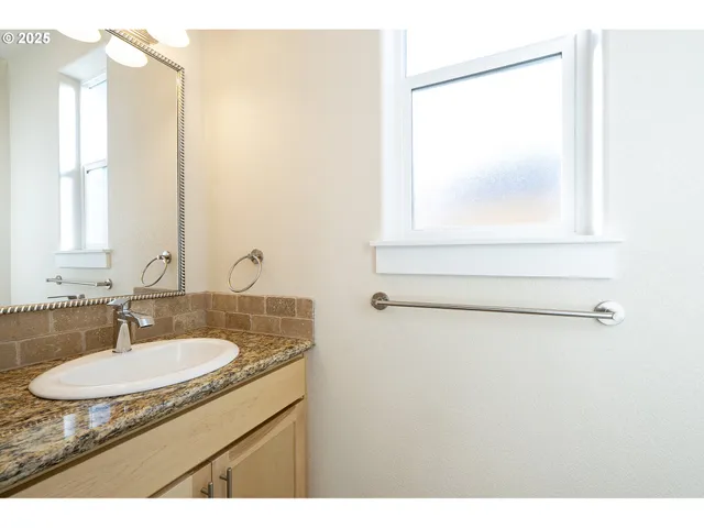 a bathroom with a granite countertop sink a mirror and a vanity