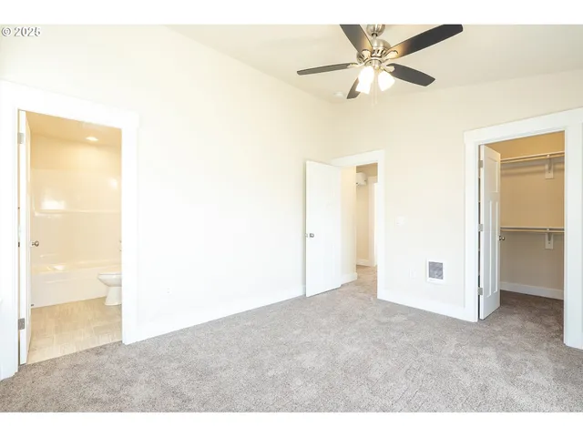 a view of an empty room with a ceiling fan