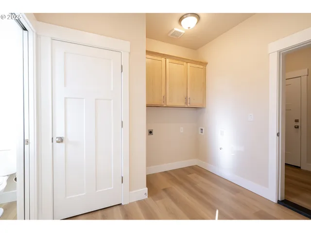 a view of an empty room with wooden floor and closet