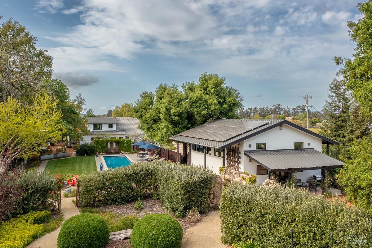 an aerial view of a house with swimming pool and lake view