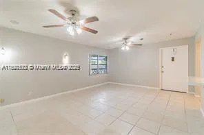 an empty room with fan and windows