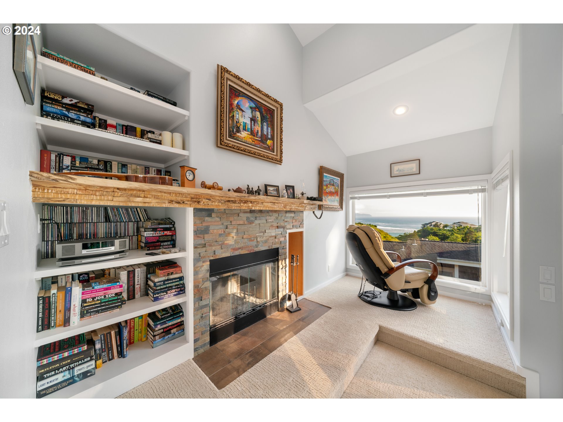 505 Capes Drive, Unit 5 Oceanside, OR 97141 - Photo 15 of 37 a living room with furniture a rug a fireplace and a book shelf