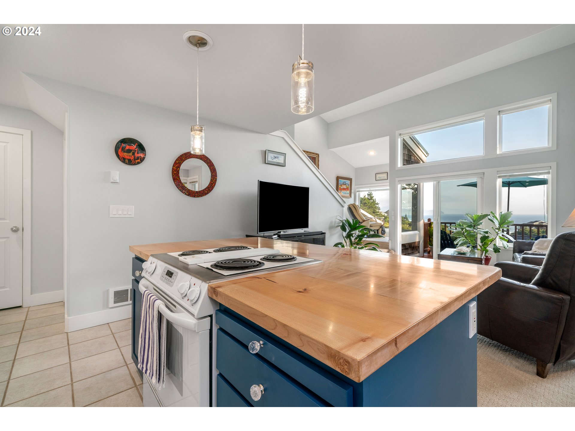 505 Capes Drive, Unit 5 Oceanside, OR 97141 - Photo 6 of 37 a kitchen with a stove a microwave a dining table and chairs