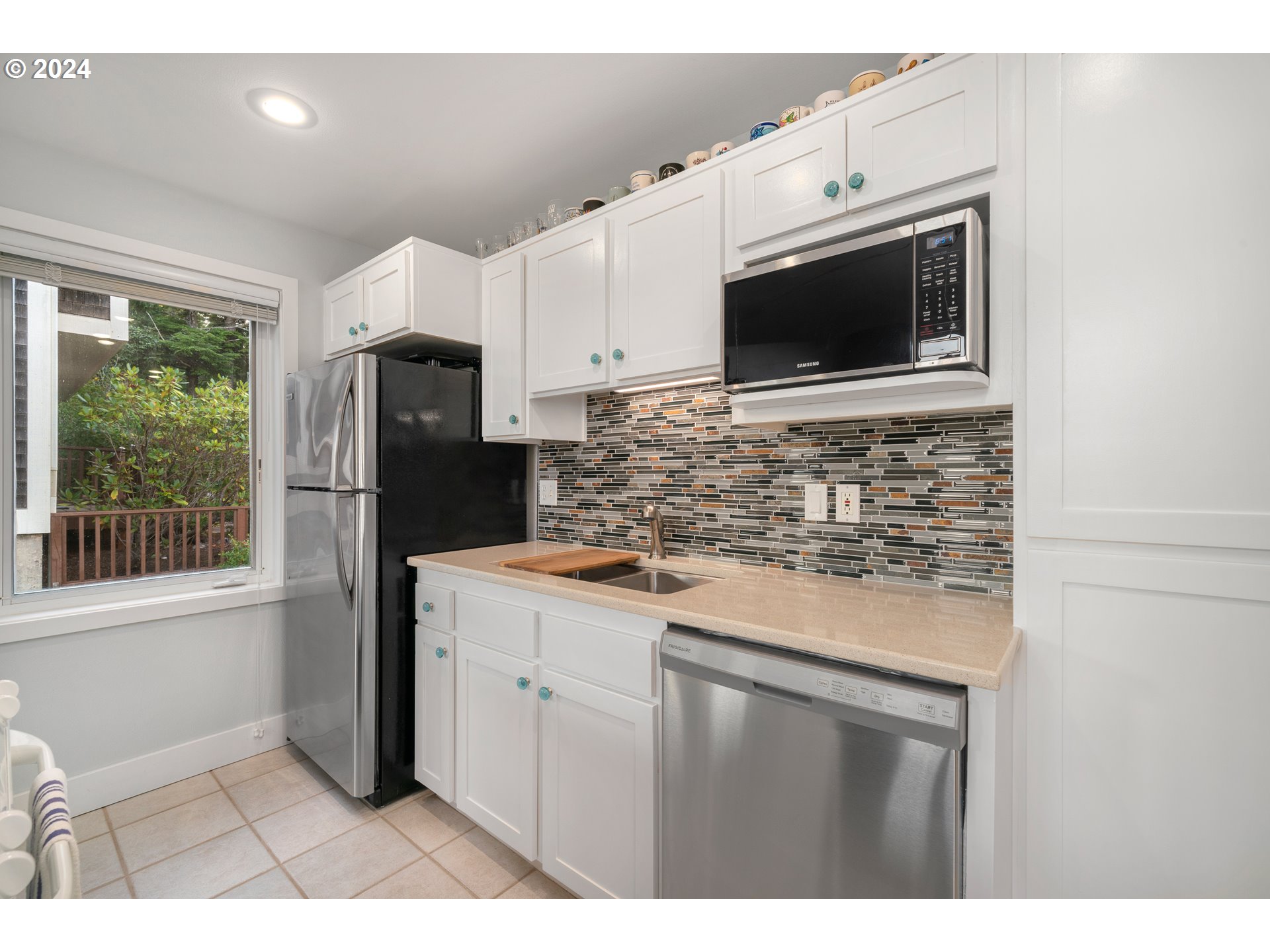 505 Capes Drive, Unit 5 Oceanside, OR 97141 - Photo 8 of 37 a kitchen with stainless steel appliances granite countertop a stove microwave and refrigerator