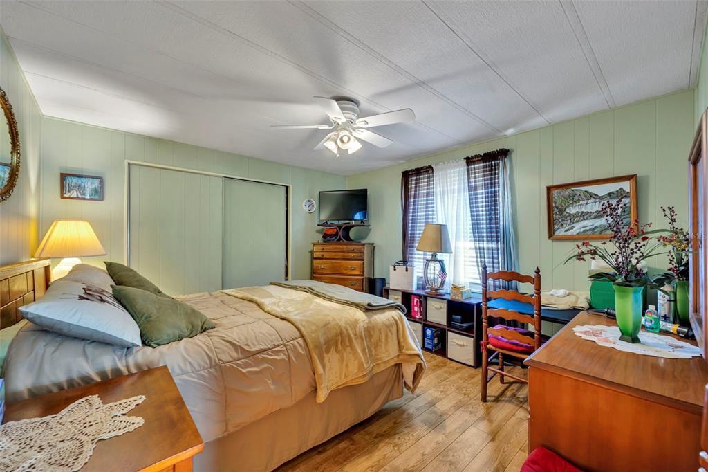 223 Paradise Leesburg, FL 34788 - Photo 18 of 43 a bedroom with a bed and a chandelier