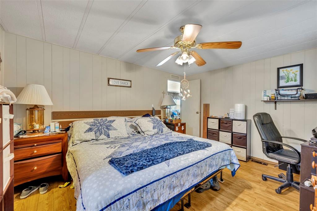 223 Paradise Leesburg, FL 34788 - Photo 21 of 43 a bedroom with a bed a desk and chair
