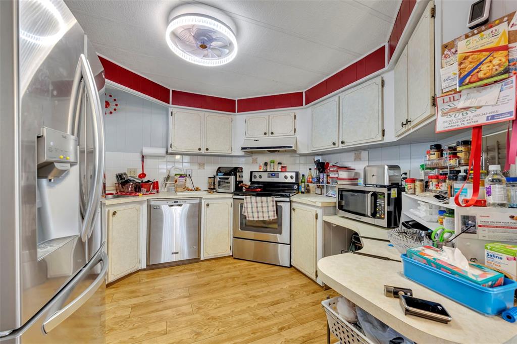 223 Paradise Leesburg, FL 34788 - Photo 7 of 43 a kitchen with a refrigerator and a stove top oven