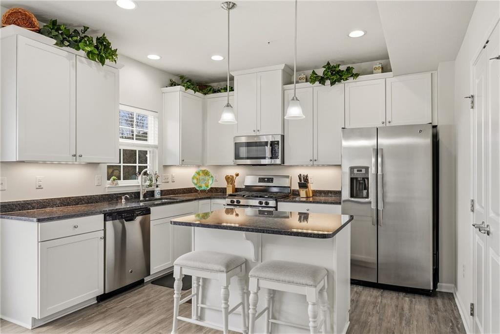 103 John Street Washington, PA 15301 - Photo 15 of 39 a kitchen with stainless steel appliances granite countertop a refrigerator a sink dishwasher a stove and white cabinets with wooden floor