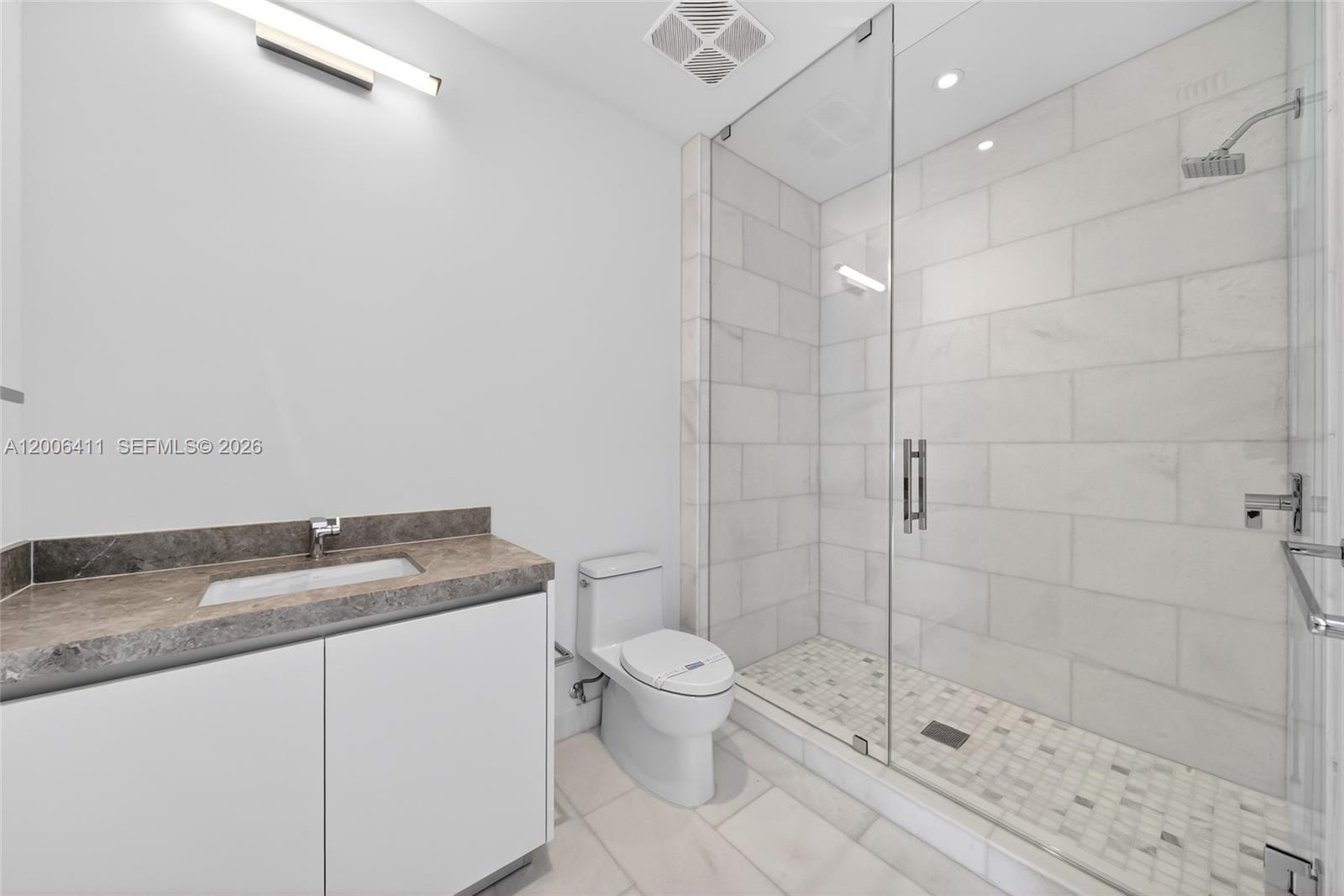 175 Southeast 25th Road, Unit 1202 Miami, FL 33129 - Photo 36 of 74 a bathroom with a granite countertop sink a toilet and shower