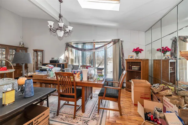 a view of a dining room with furniture a chandelier and wooden floor