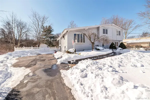 a front view of a house with a yard covered in snow