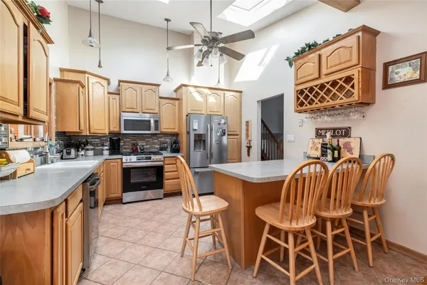 a kitchen with stainless steel appliances kitchen island granite countertop a table chairs and a refrigerator