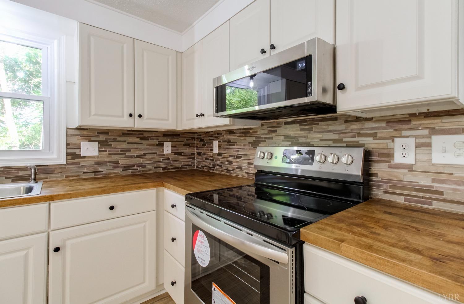 152 Hanger Road Amherst, VA 24521 - Photo 8 of 27 a kitchen with stainless steel appliances a stove a microwave sink and cabinets