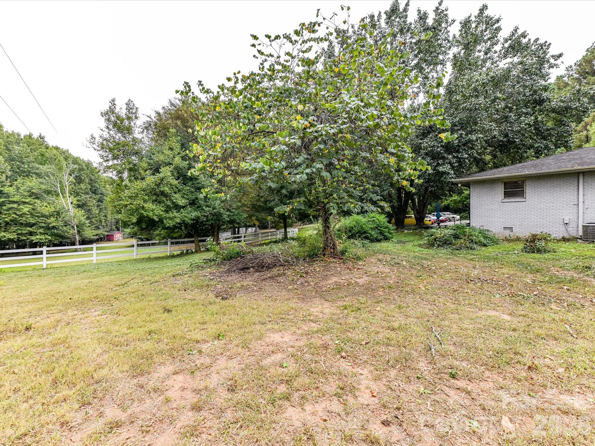 a view of backyard with swimming pool and trees in the background