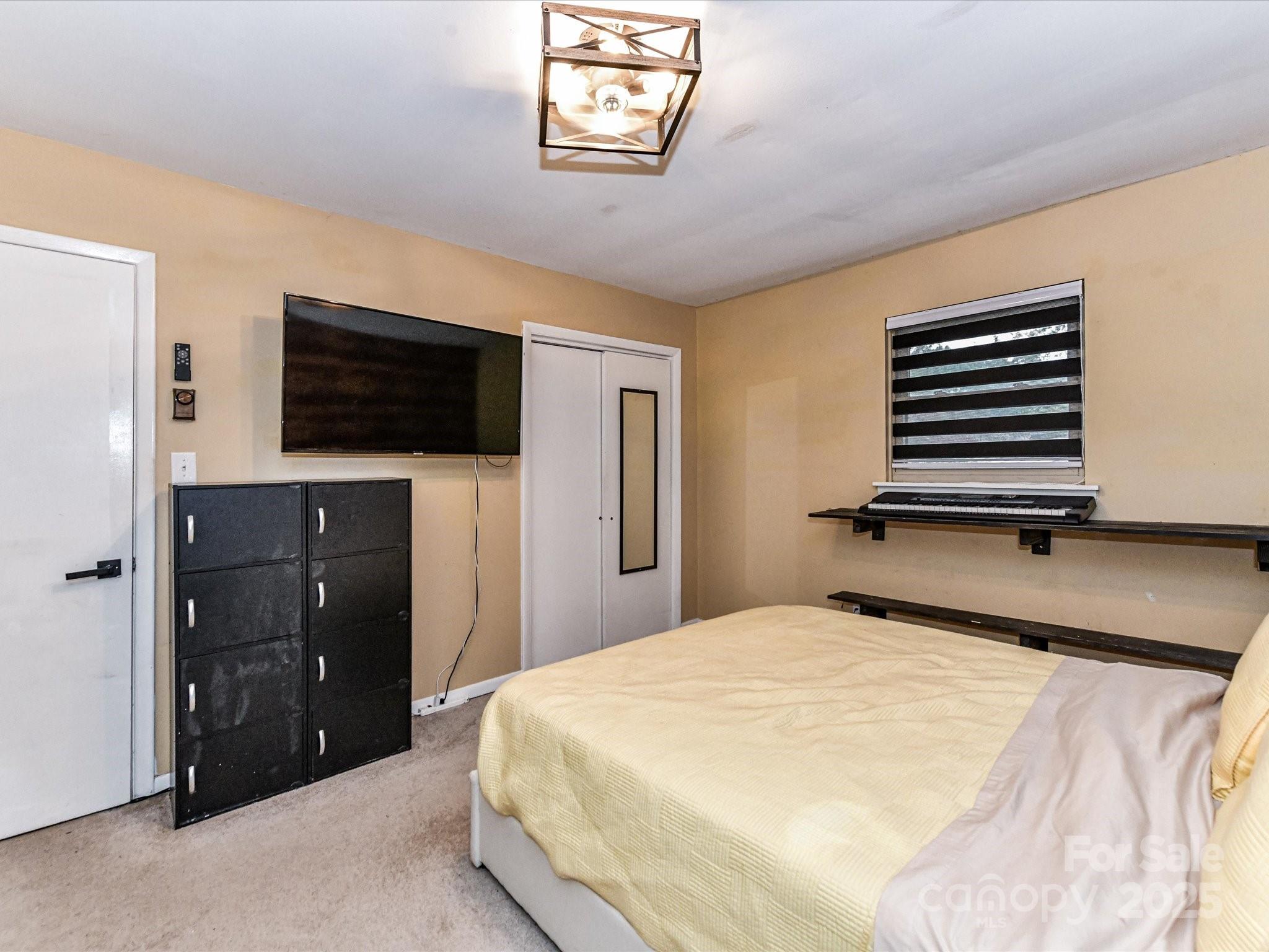 4500 Matthews-Mint Hill Road Matthews, NC 28105 - Photo 21 of 40 a bedroom with a bed and a flat screen tv