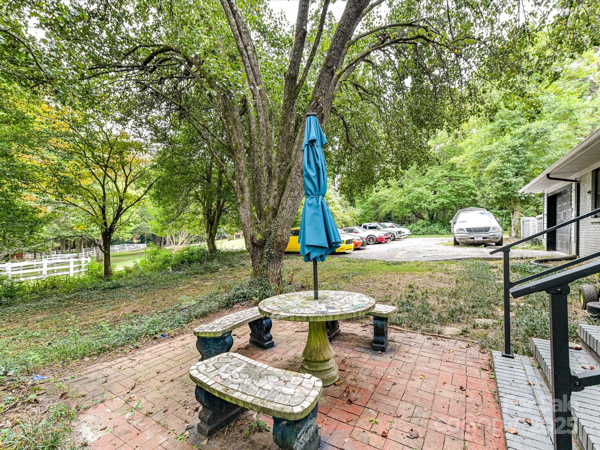 4500 Matthews-Mint Hill Road Matthews, NC 28105 - Photo 29 of 40 a view of a patio with table and chairs potted plants and a large tree