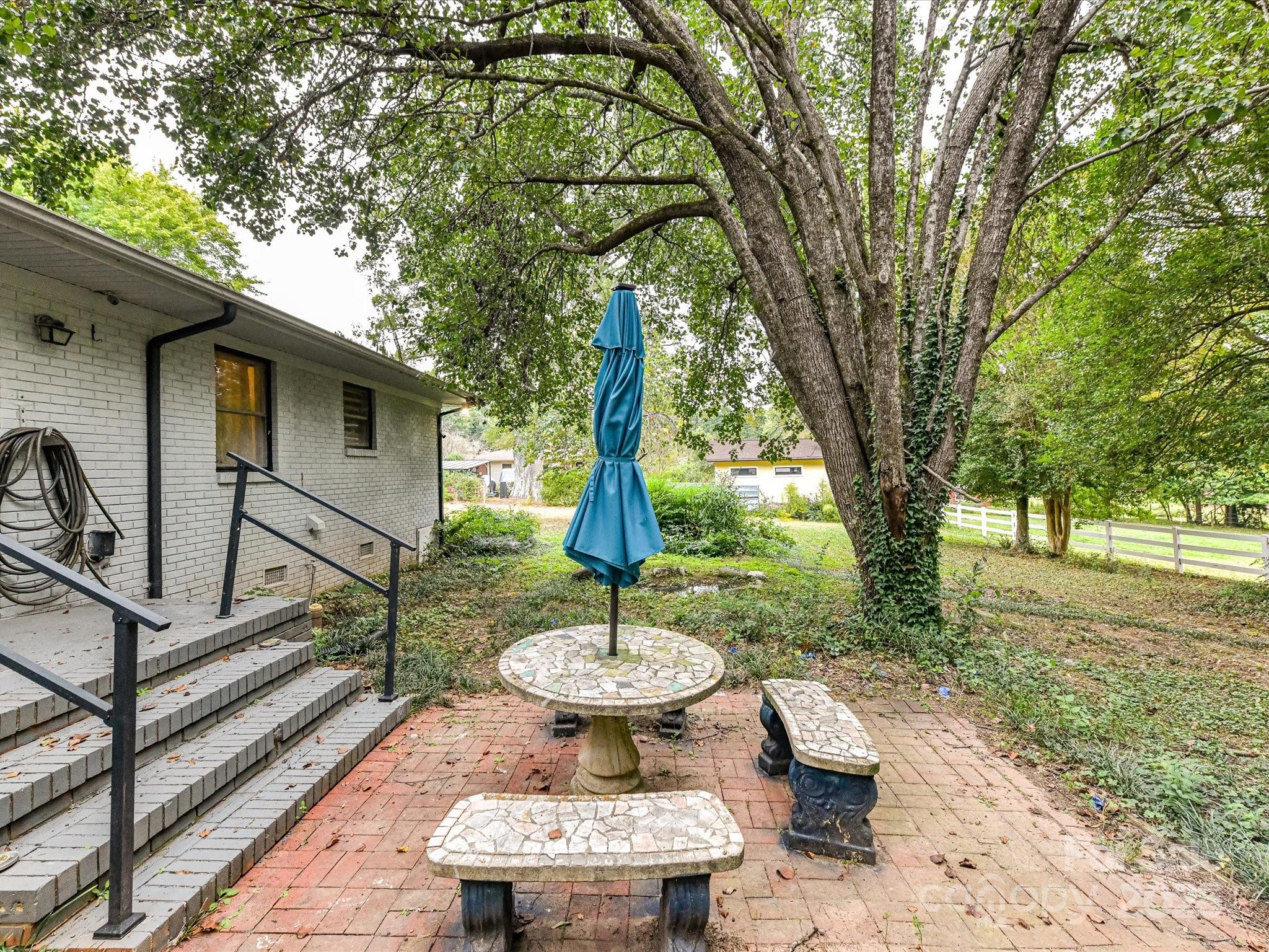 4500 Matthews-Mint Hill Road Matthews, NC 28105 - Photo 31 of 40 a view of a backyard with table and chairs potted plants and a large tree