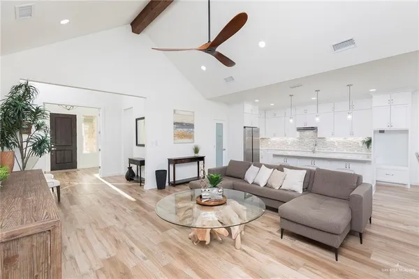a living room with furniture kitchen and a table