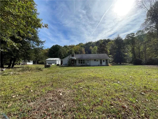 a house with green field in front of it