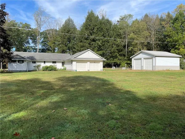 a view of a house with a yard and sitting area