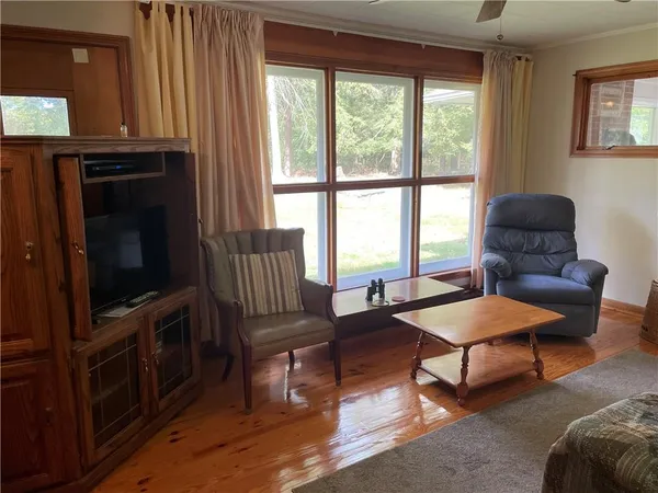 a living room with furniture a flat screen tv and a large window