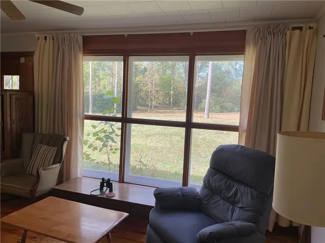 a living room with furniture a ceiling fan and a window