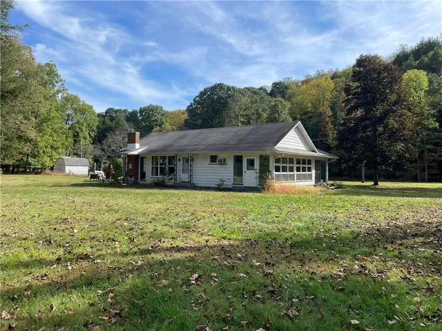 a front view of a house with a yard and trees