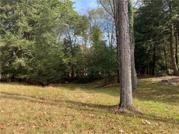 a view of a house with a big yard and large trees