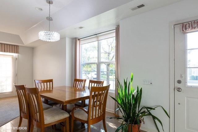 13402 Delaney Road Huntley, IL 60142 - Photo 3 of 16 a dining room with furniture potted plants and wooden floor