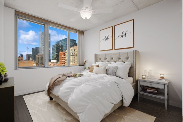 a bedroom with a bed and a large window with outer view