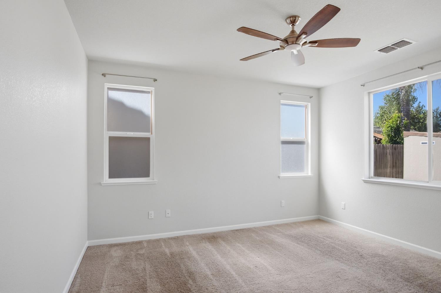 4113 Snowfire Drive Modesto, CA 95357 - Photo 14 of 19 an empty room with windows and fan