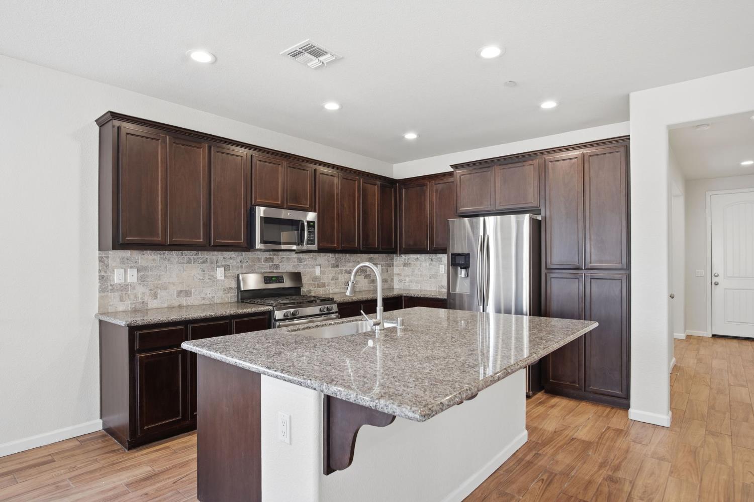 4113 Snowfire Drive Modesto, CA 95357 - Photo 5 of 19 a kitchen with stainless steel appliances granite countertop a sink microwave and cabinets