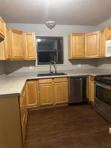 a kitchen with a sink stove top oven and refrigerator