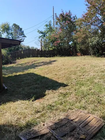 a view of a yard with wooden fence
