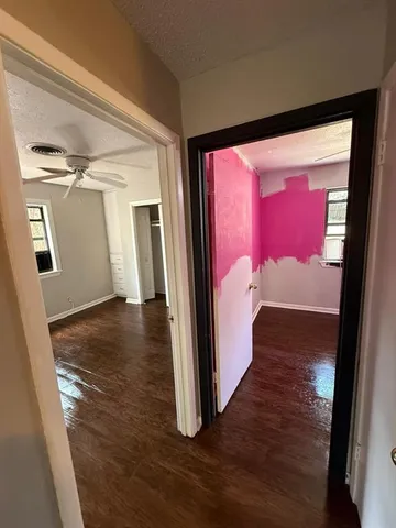 a view of a hallway with wooden floor