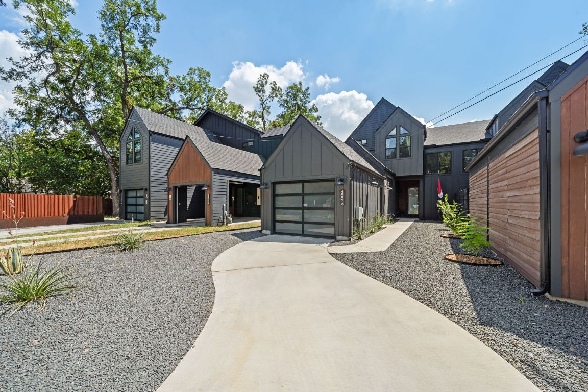 View of front of house with board and batten siding, concrete driveway, an attached garage, and a shingled roof