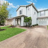 a view of a white house with a big yard and palm trees