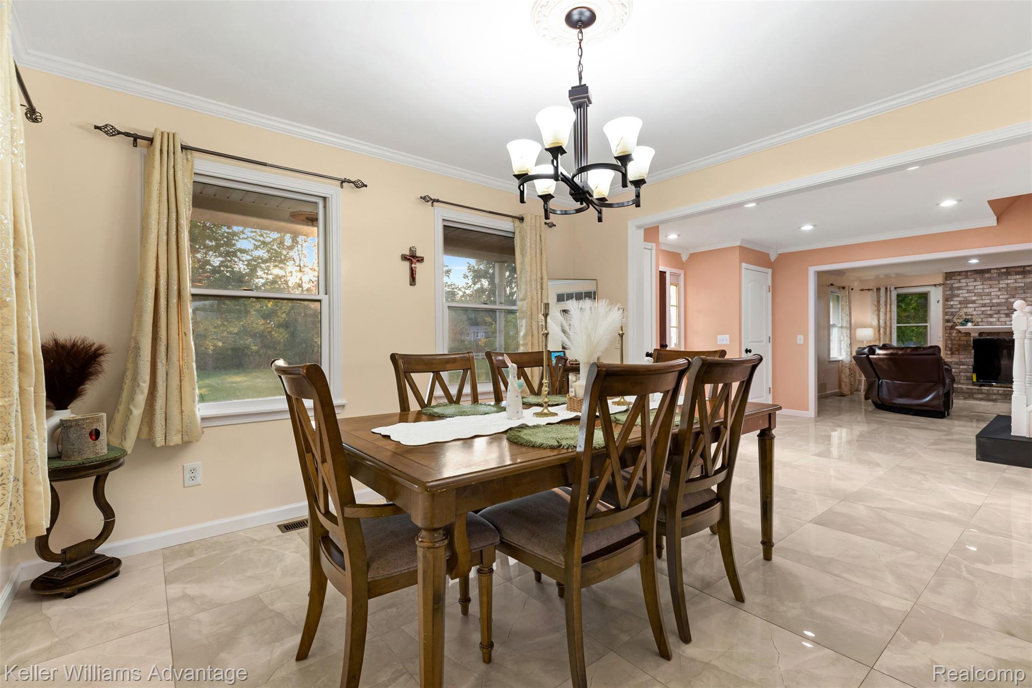 22627 Otter Road New Boston, MI 48164 - Photo 6 of 52 Dining area featuring a wood dining table with six chairs, a traditional chandelier, two windows, and light-toned tile flooring