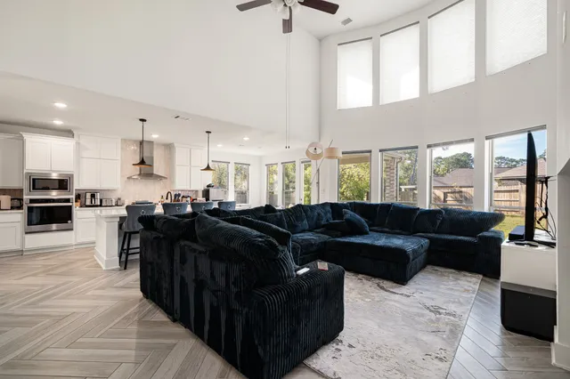 a living room with furniture and a view of kitchen