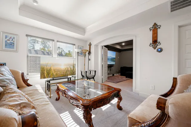 a living room with furniture a flat screen tv and a large window