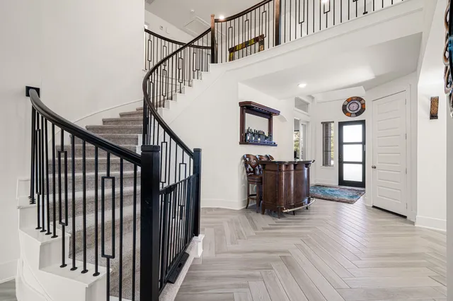 a view of a hallway with wooden floor and stairs