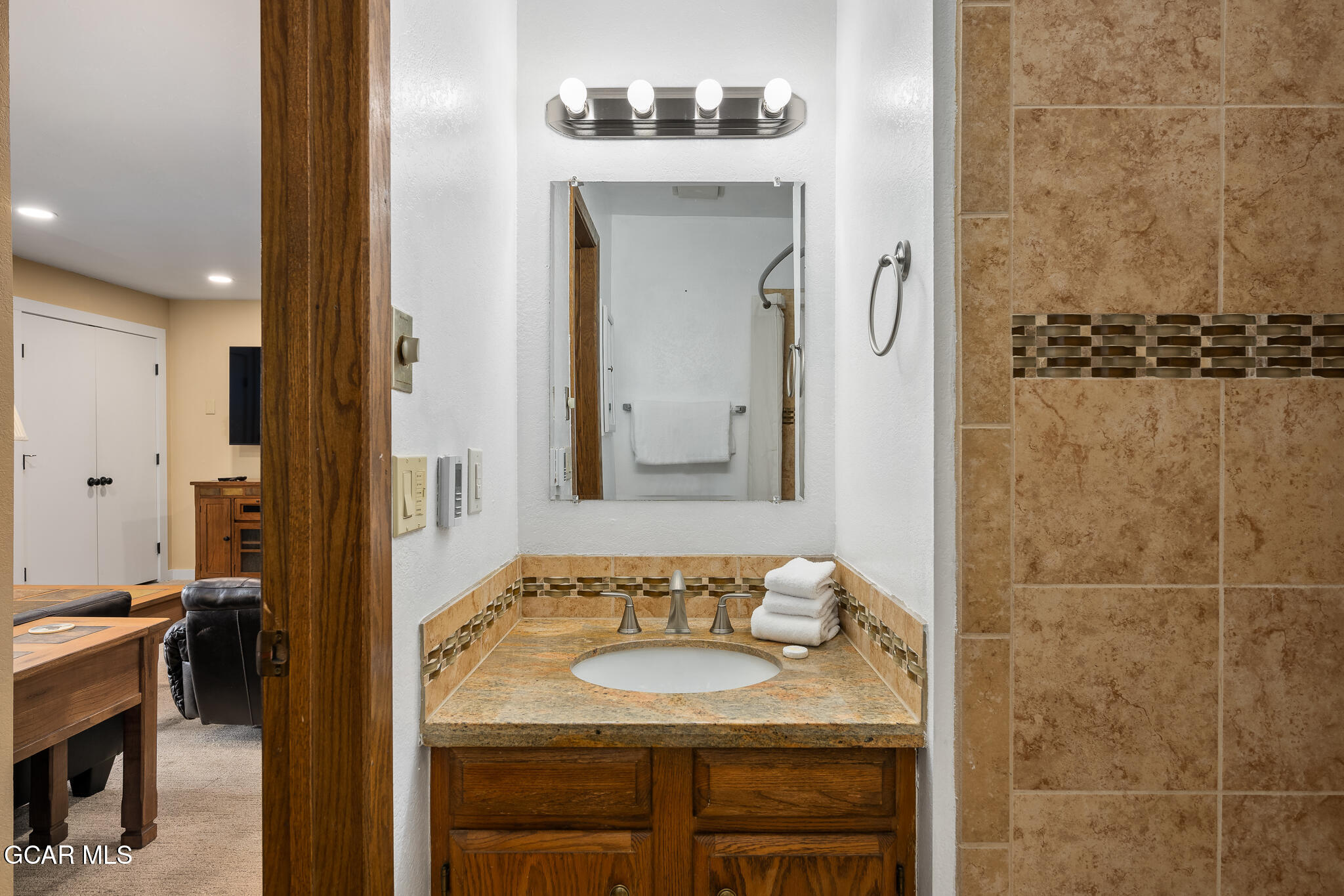 490 Kings Crossing Road, Unit 611 Winter Park, CO 80482 - Photo 30 of 39 a bathroom with a granite countertop sink and a mirror