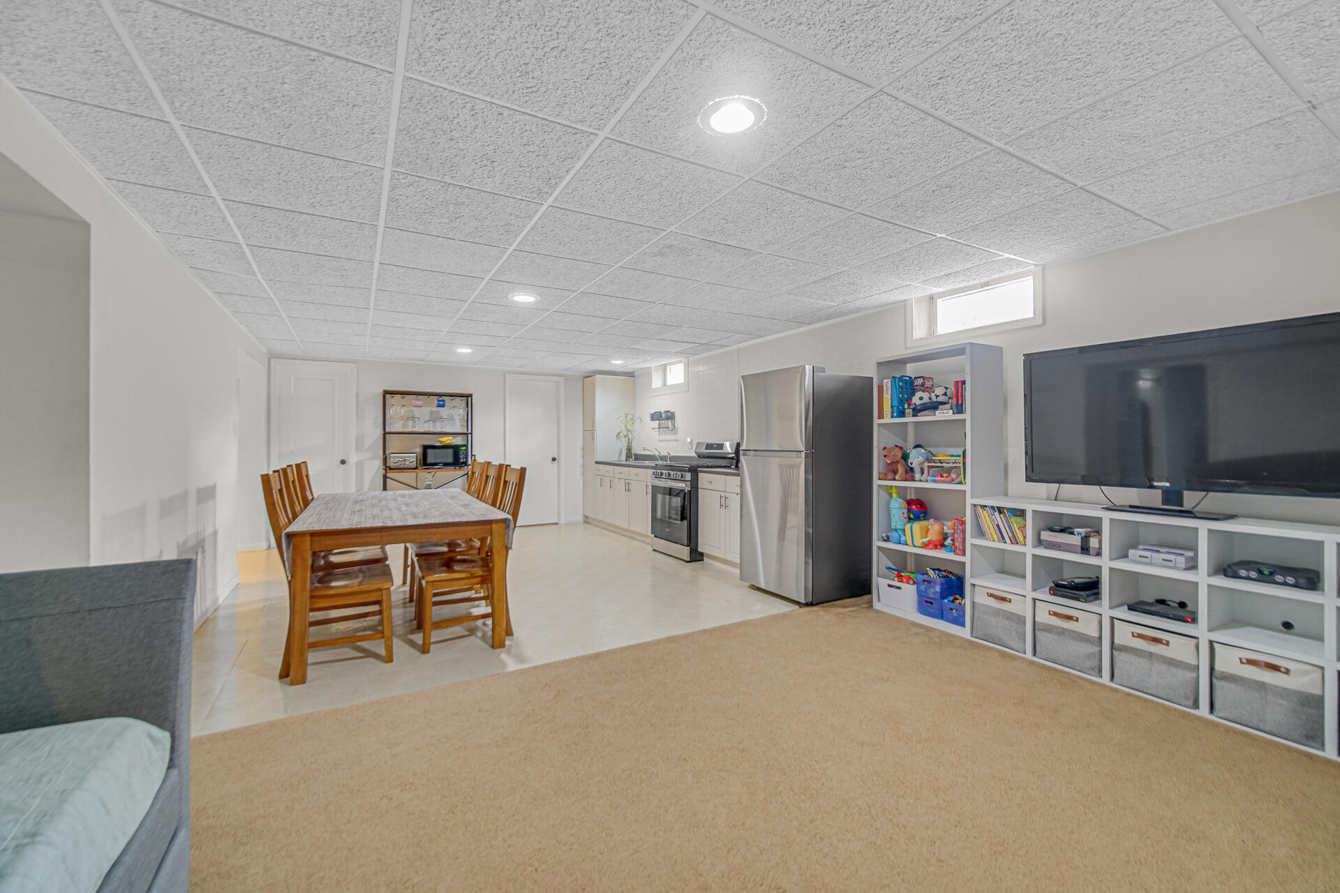4942 West 93rd Court Crown Point, IN 46307 - Photo 23 of 37 a living room with furniture a flat screen tv and kitchen view