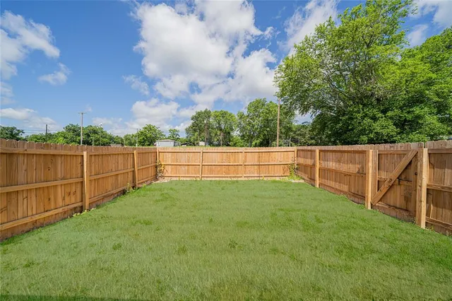 a view of backyard with wooden fence