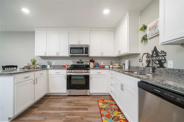 a kitchen with granite countertop a sink and a stove top oven