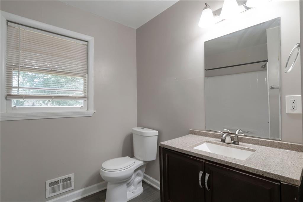 904 Pine Roc Drive Stone Mountain, GA 30083 - Photo 14 of 15 a bathroom with a sink toilet and a mirror