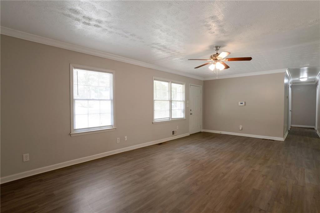 904 Pine Roc Drive Stone Mountain, GA 30083 - Photo 6 of 15 an empty room with wooden floor and window