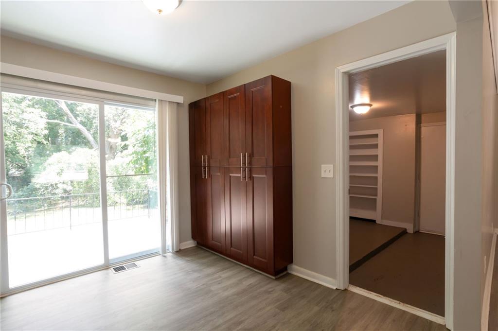 904 Pine Roc Drive Stone Mountain, GA 30083 - Photo 9 of 15 an empty room with wooden floor and windows